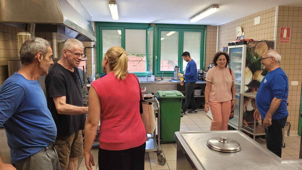 Miriam Martón saluda a uno de los miembros de la Comunidad en la visita a las cocinas.