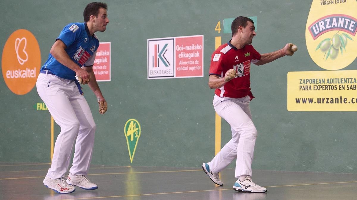 Agirre golpea la pelota ante la mirada de Darío.