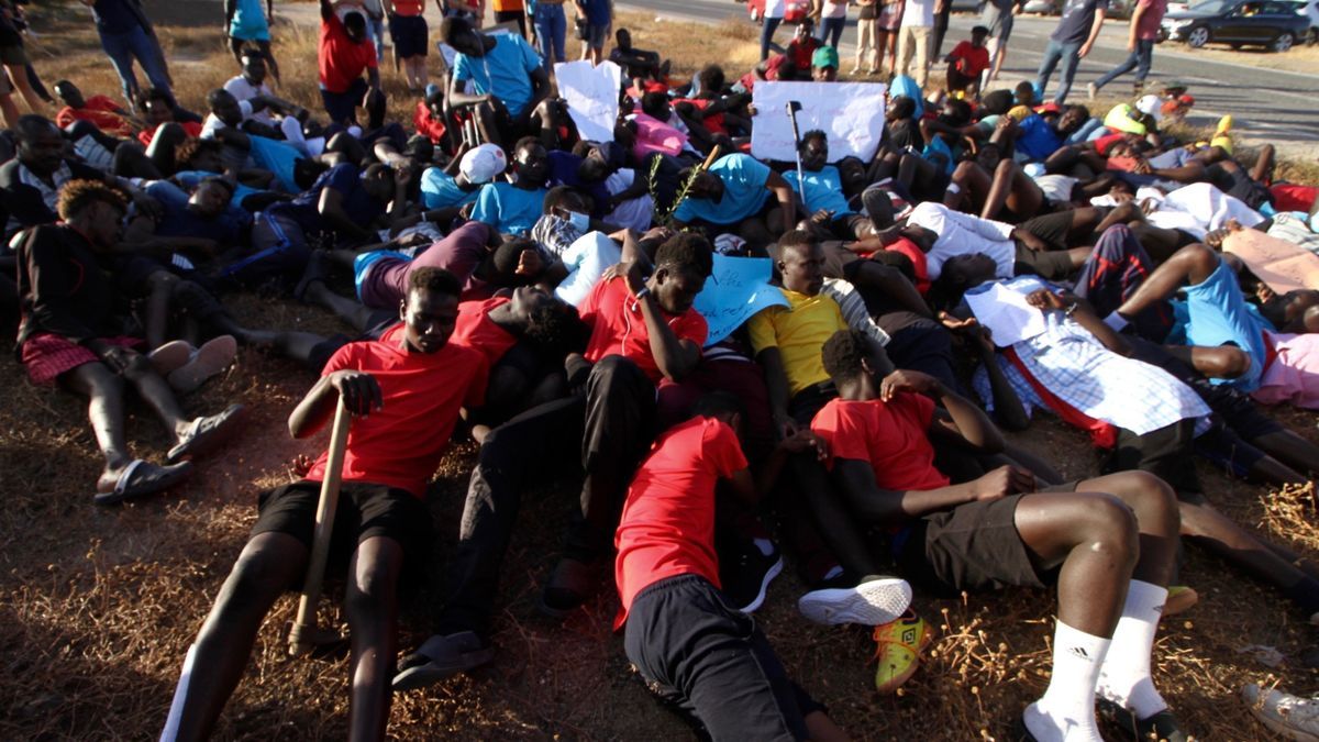Migrantes protestan simulando las imágenes de los cuerpos tendidos en el salto a la valla de Melilla.
