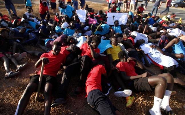 Migrantes protestan simulando las imágenes de los cuerpos tendidos en el salto a la valla de Melilla. Migrantes protestan simulando las imágenes de los cuerpos tendidos en el salto a la valla de Melilla.