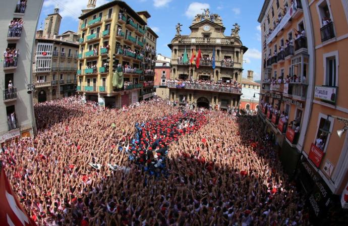 Mozos elevando sus manos al compás de la música de los gaiteros tras el lanzamiento del Chupinazo de 2018.