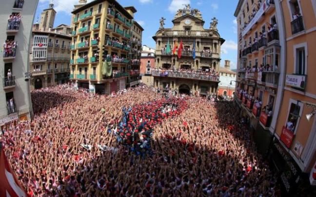 Mozos elevando sus manos al compás de la música de los gaiteros tras el lanzamiento del Chupinazo de 2018.