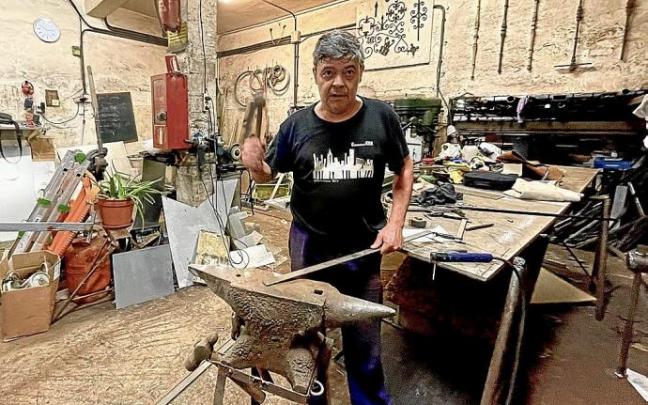 Juan Mari Kortadi, en su herrería de la calle Juan de Bilbao, trabajando con el yunque.