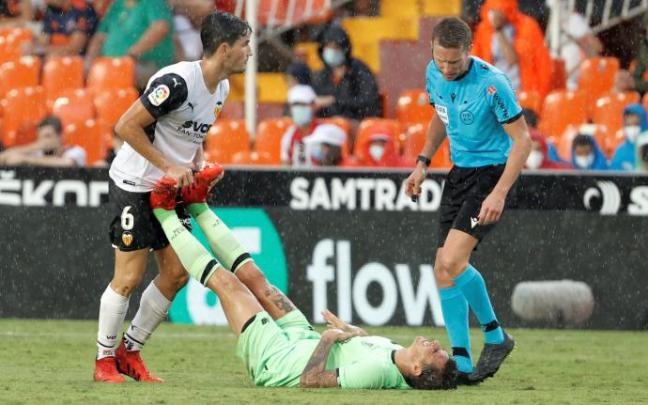 Hugo Guillamón ayuda a Dani García, que se duele en el suelo.