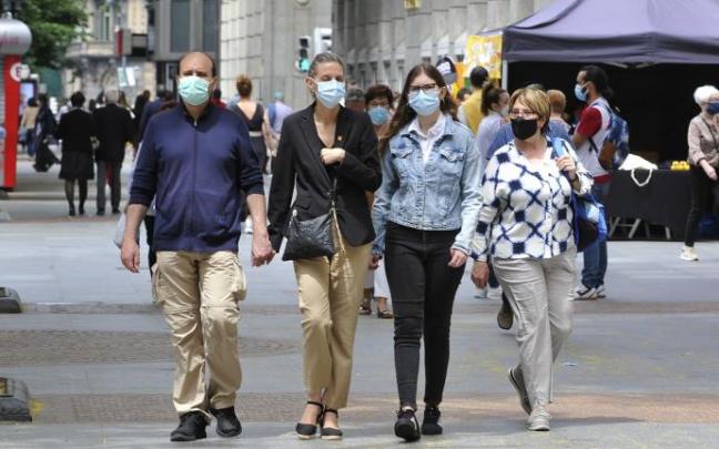Gente paseando con mascarilla.