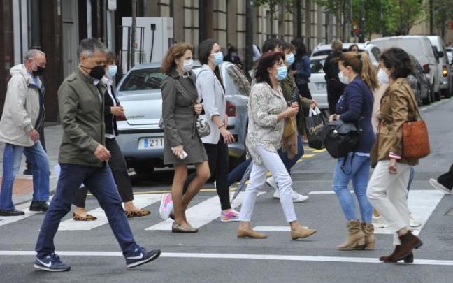 Gente paseando con mascarilla.