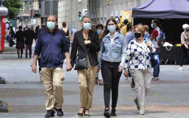 Gente paseando con mascarilla.