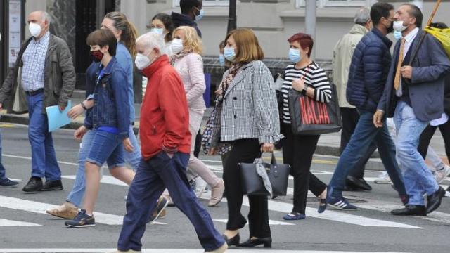 Gente paseando con mascarilla.