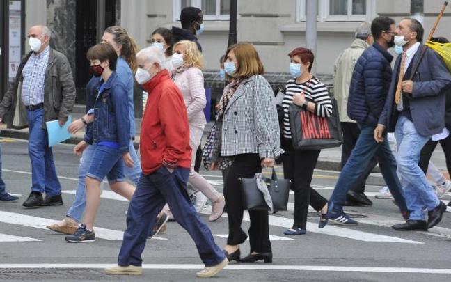 Gente paseando con mascarilla.