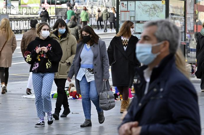 Varias personas pasean con mascarilla.