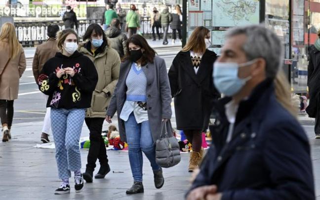 Varias personas pasean con mascarilla.
