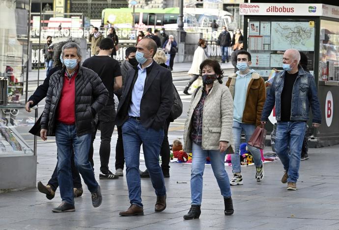 Varias personas pasean con mascarilla.