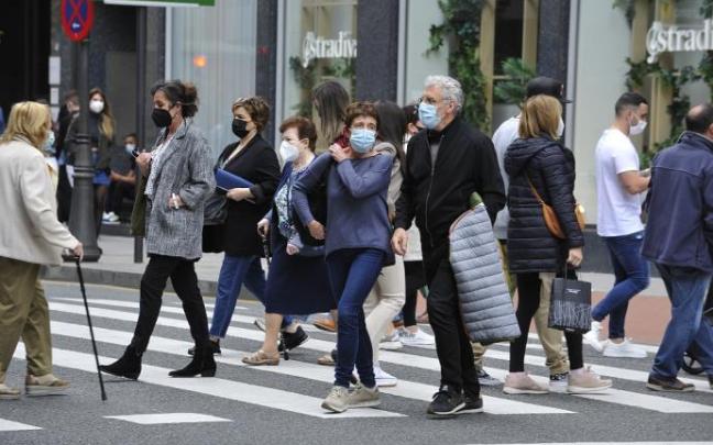 Personas paseando con mascarilla.