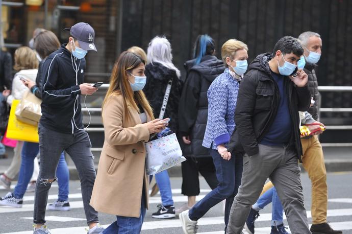 Gente paseando con mascarilla.