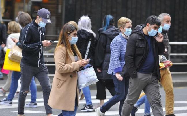 Gente paseando con mascarilla.