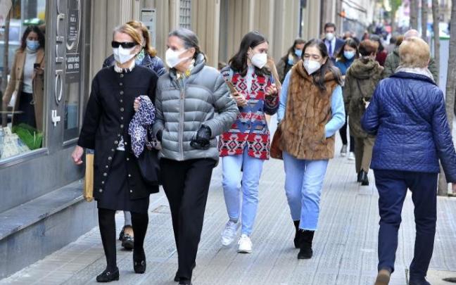 Gente paseando con mascarilla.
