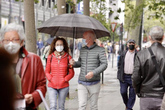 Personas andando por la calle con mascarilla.