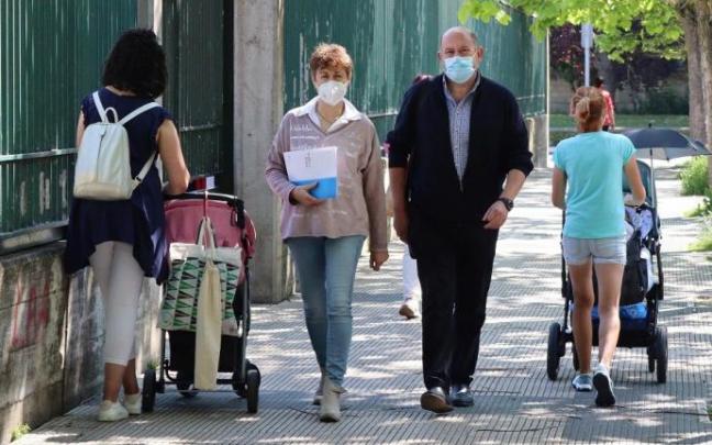 Varias personas andando por la calle con mascarilla.