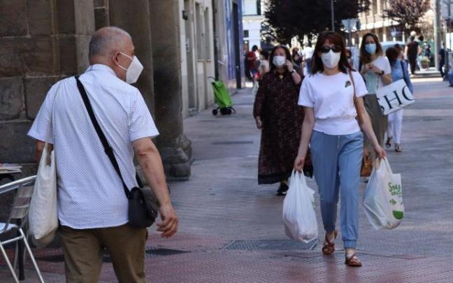 Personas andando por la calle con mascarilla para evitar contagios de coronavirus.