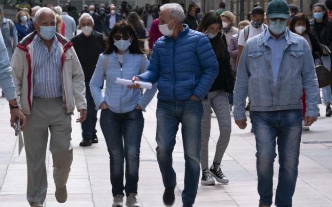 Personas andando por la calle con mascarilla.