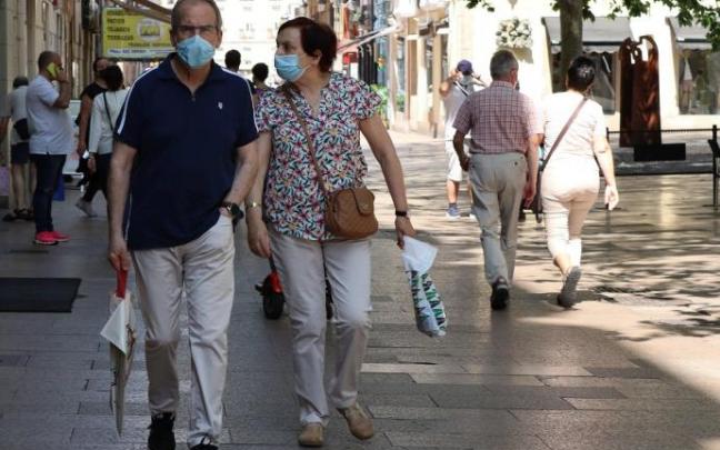 Personas andando por la calle con mascarilla.
