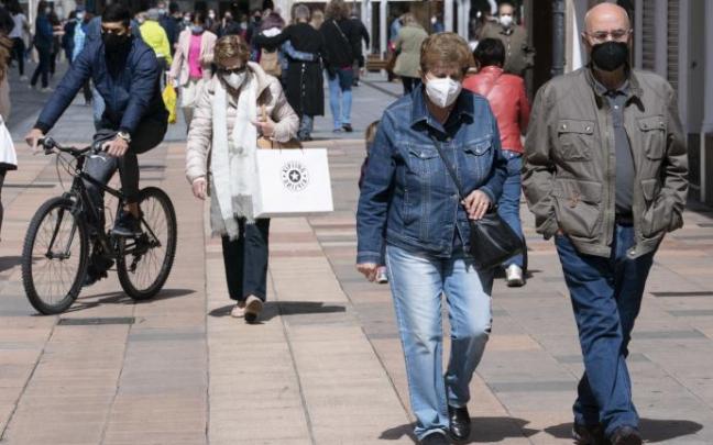 Personas andando por la calle con mascarilla.