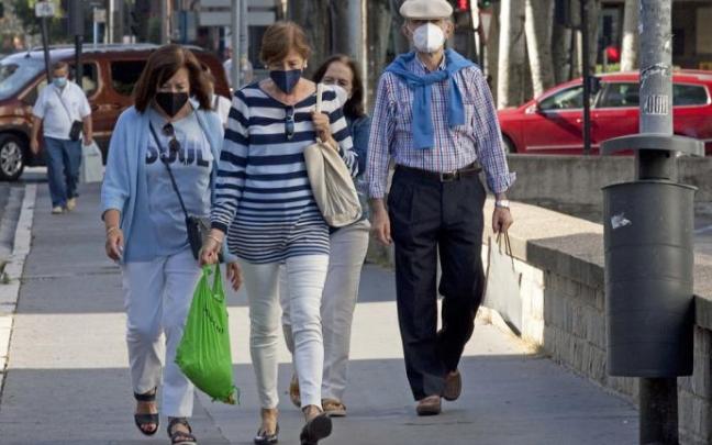 Personas andando por la calle con mascarilla.