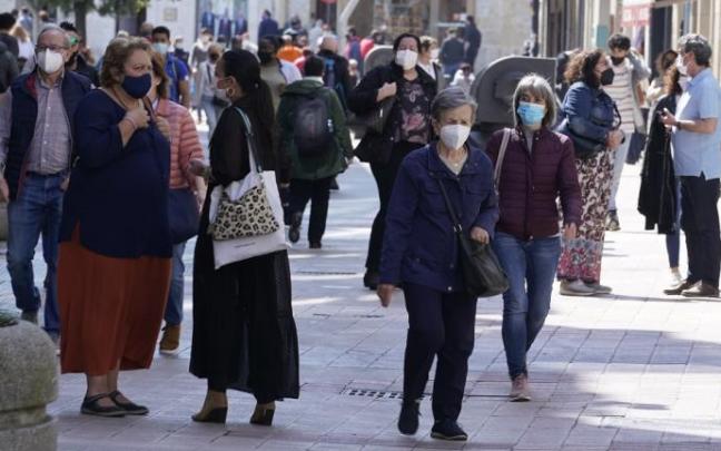 Personas paseando por la calle con mascarilla.