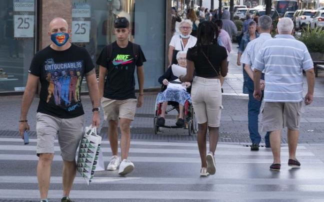 Varias personas caminan por la calle.