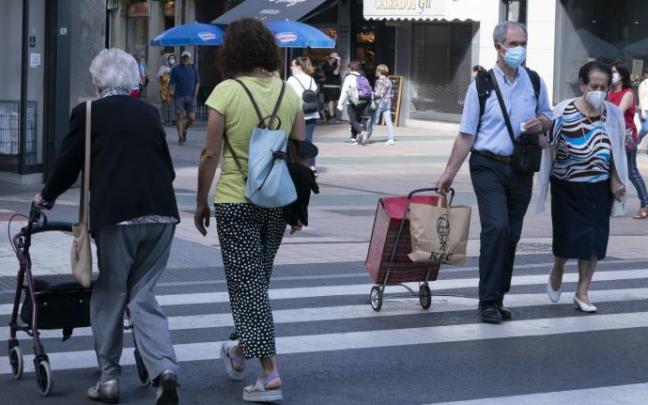 Varias personas paseando con mascarilla.