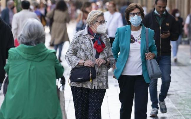 Personas andando por la calle con mascarilla.