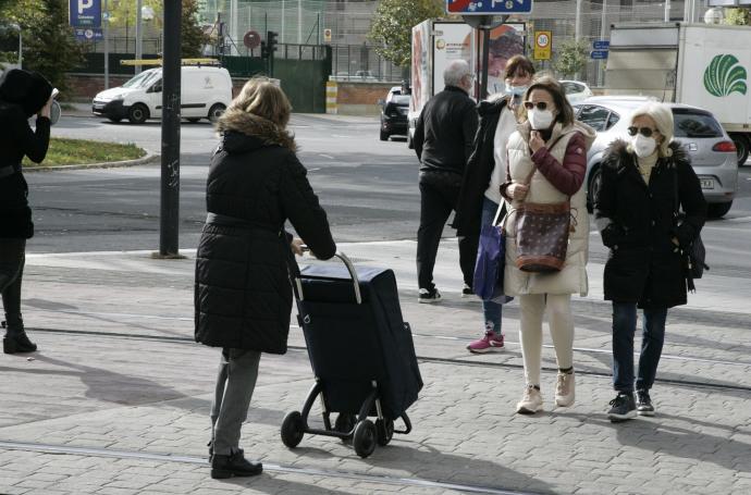 Personas andando por la calle con mascarilla.