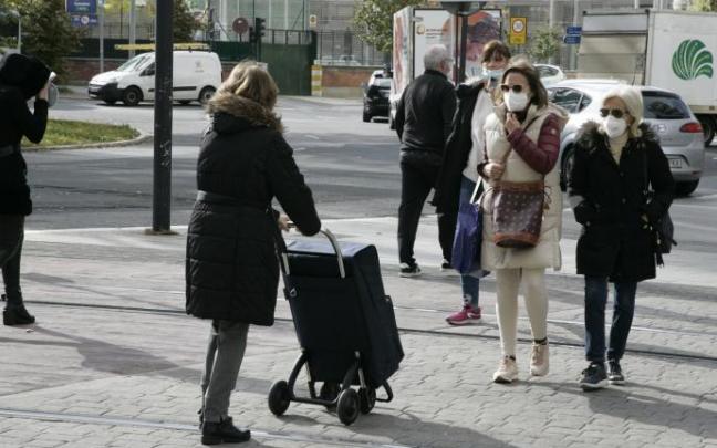 Personas andando por la calle con mascarilla.