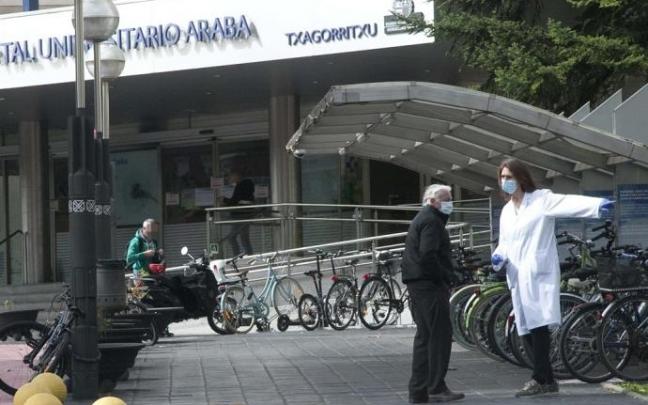 Varias personas con mascarilla en el exterior del hospital Txagorritxu.