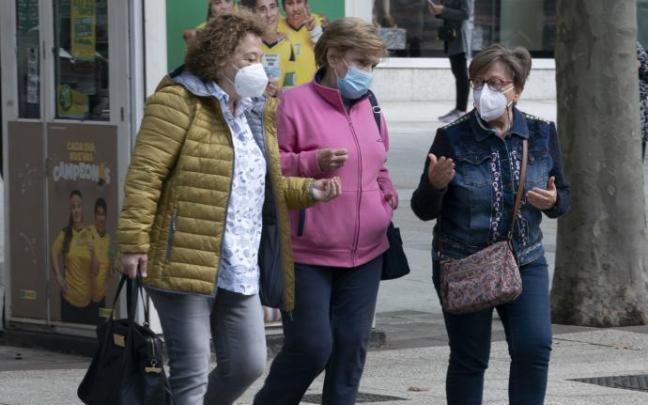 Personas andando por la calle con mascarilla.