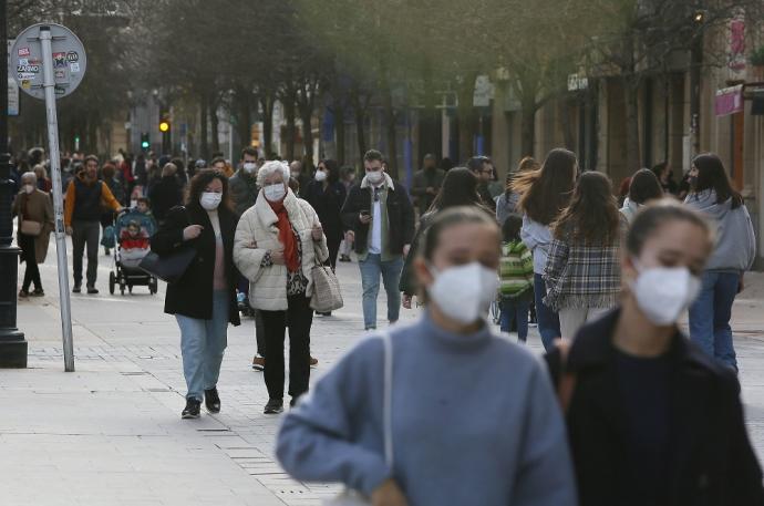 Personas andando por la calle con mascarilla.