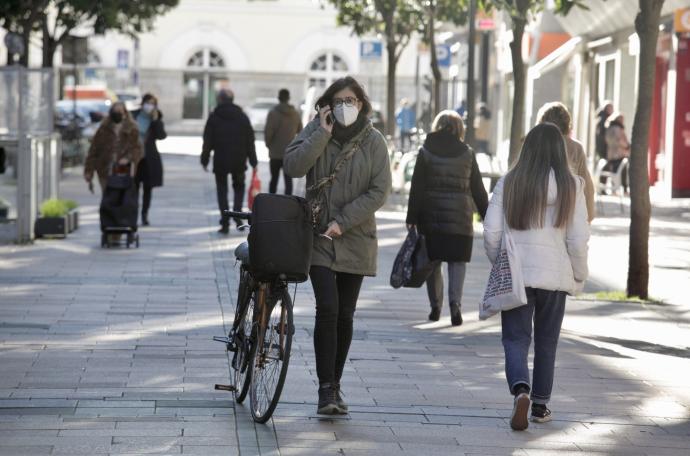 Personas andando por la calle con mascarilla.