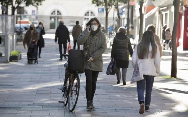 Personas andando por la calle con mascarilla.