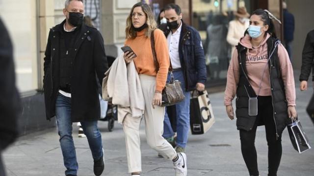 Varias personas caminan por la calle.