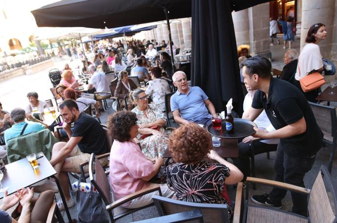 Varias personas tomando algo una terraza de un bar de Bilbao.