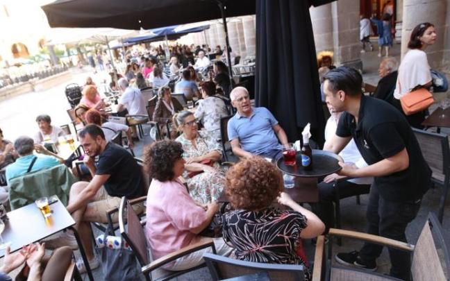 Varias personas tomando algo una terraza de un bar de Bilbao.
