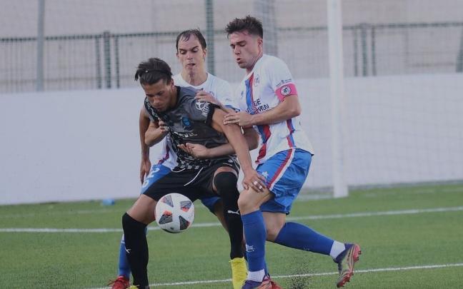 Dos defensores de la Mutilvera presionan a un rival del Alavés B en el primer partido liguero. Dos defensores de la Mutilvera presionan a un rival del Alavés B en el primer partido liguero.