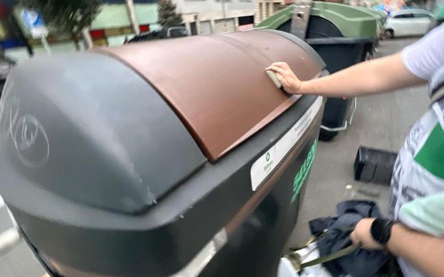 Una persona utiliza el contenedor marrón en Bilbao.