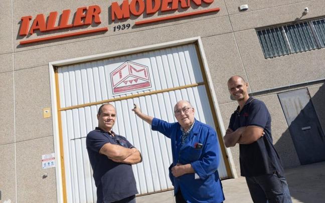 Manuel Angós, en el centro, con dos de sus hijos, frente al Taller Moderno