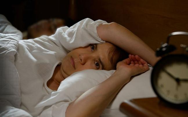 Una mujer se despierta en medio de la noche. Una mujer se despierta en medio de la noche.