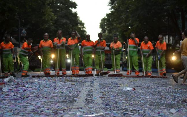 Operarios del servicio de limpieza del Ayuntamiento de Bilbao barriendo tras el desfile de la ballena.