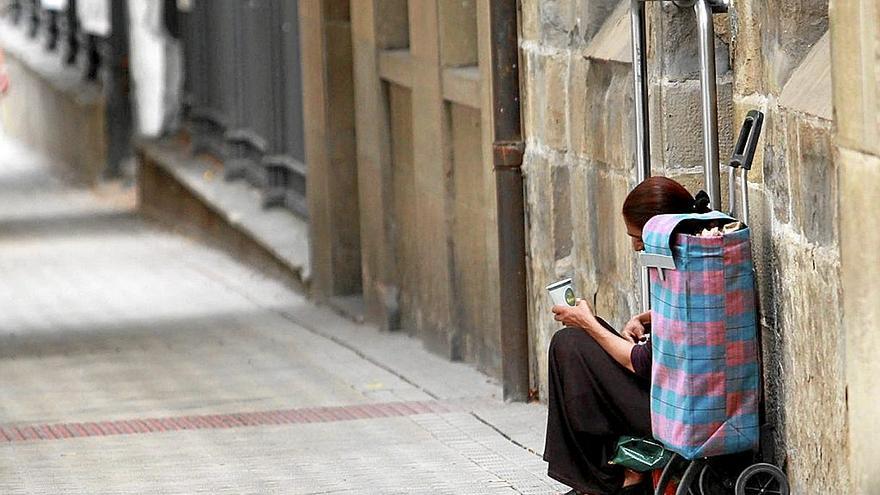 Una mujer pide limosna en una calle de Pamplona.