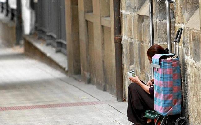 Una mujer pide limosna en una calle de Pamplona.