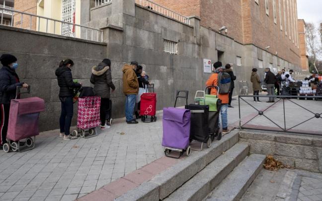 Un grupo de personas hace cola para recibir ayuda alimentaria. Un grupo de personas hace cola para recibir ayuda alimentaria.