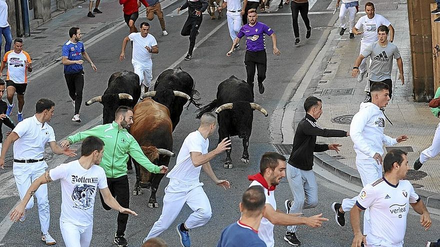 Mozos corriendo delante de las reses en la Avenida Severino Fernández, entrando a la curva de la Farola .